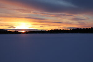 Soleil couchant sur le lac gelé Ruoksujärvi (Suède)