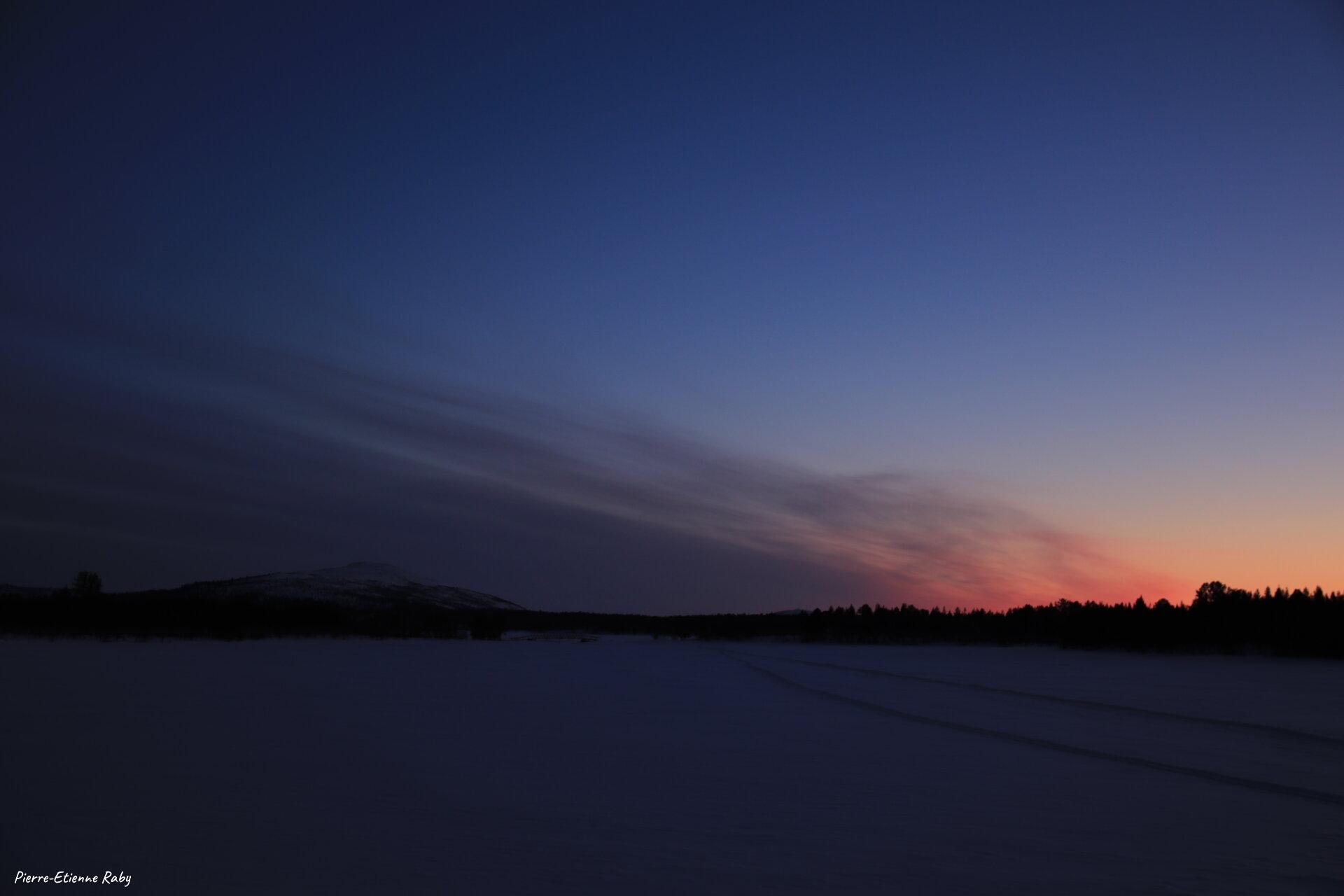 Entre nuages et soleil couchant sur le sommet de Jierivaara (Suède)